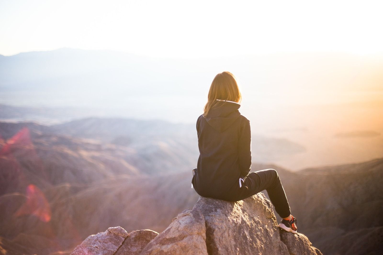 Women sitting on top of a rock